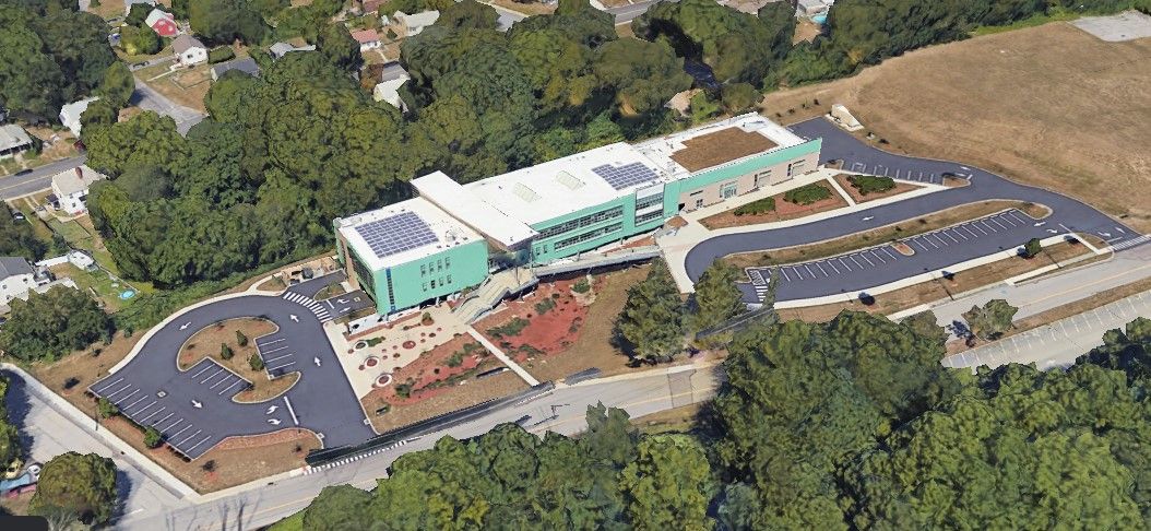 A satellite view of MSMHS shows the green roof on the right side of the image.